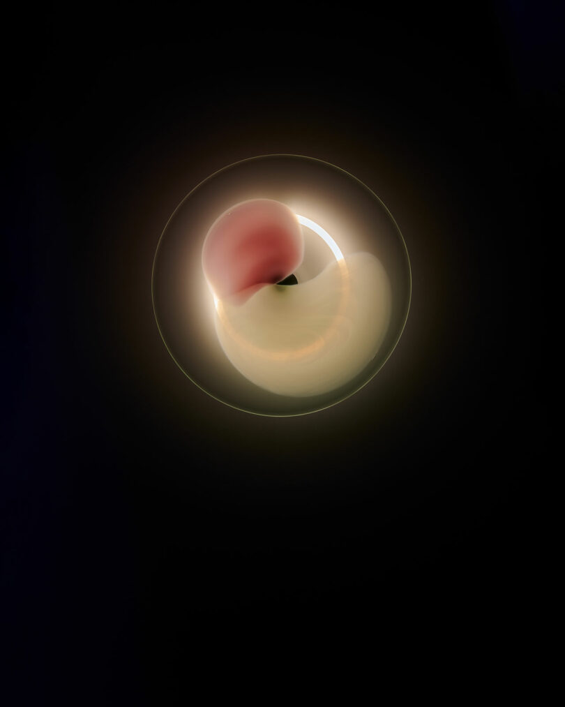 A soft, glowing orb with a pink upper section and a larger yellow lower section appears against a dark background, creating an abstract, ethereal effect.