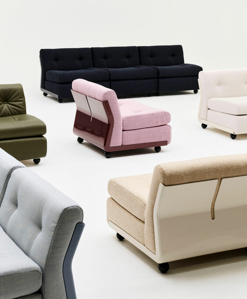 Several modern, upholstered sofas and armchairs in various colors are arranged on a plain white background.
