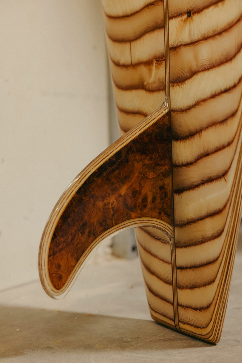 Details aus dem Detail des Holzschwanzes und der Flossen, die ein geschichtetes Holzmorn und einen Kontrast enthält, dunklere Holzeinsätze für die Finis-Calls Die Art der Signatur und Raffinesse von Kelly Wearstler.