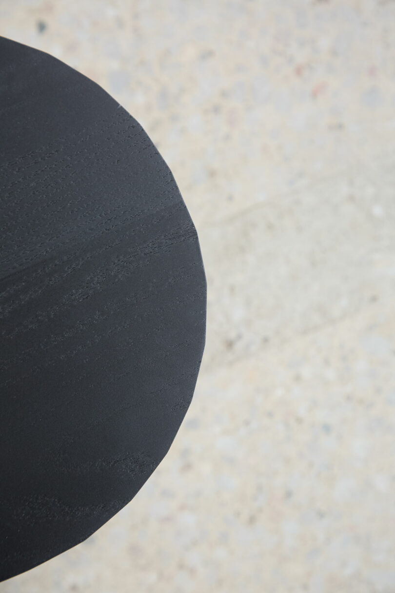 A large, sleek, a black circular object was set in the lower left corner of light, prescribes a concrete background.