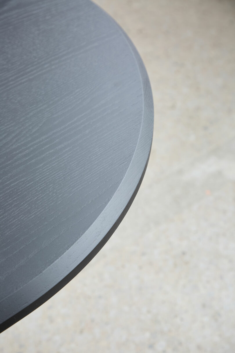 Close-up edges round, dark-colored wooden tables with textured surface, placed on light, stain.