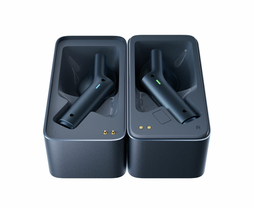 Two black wireless earbuds placed in a rectangular charging case, each in its own slot labeled "L" and "R" for left and right.