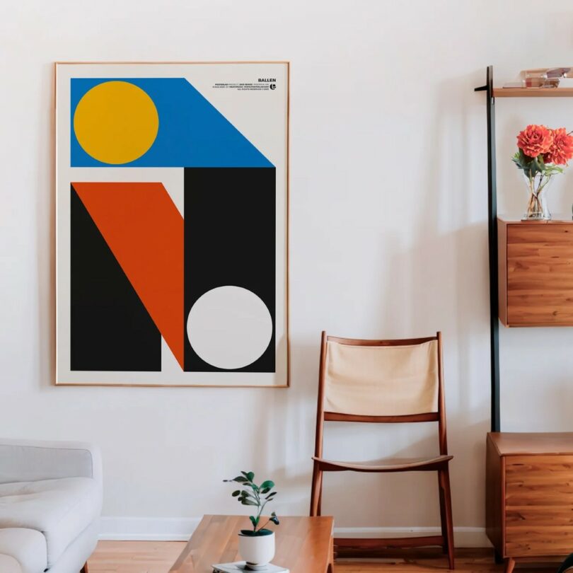 A modern living room with a large abstract geometric art print on the wall, a wooden chair with a canvas seat, shelves with flowers, and a coffee table with a small plant