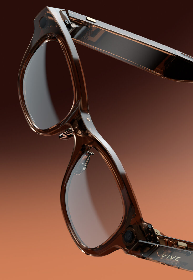 Close-up of transparent brown eyeglasses with visible internal components, set against a gradient brown background.
