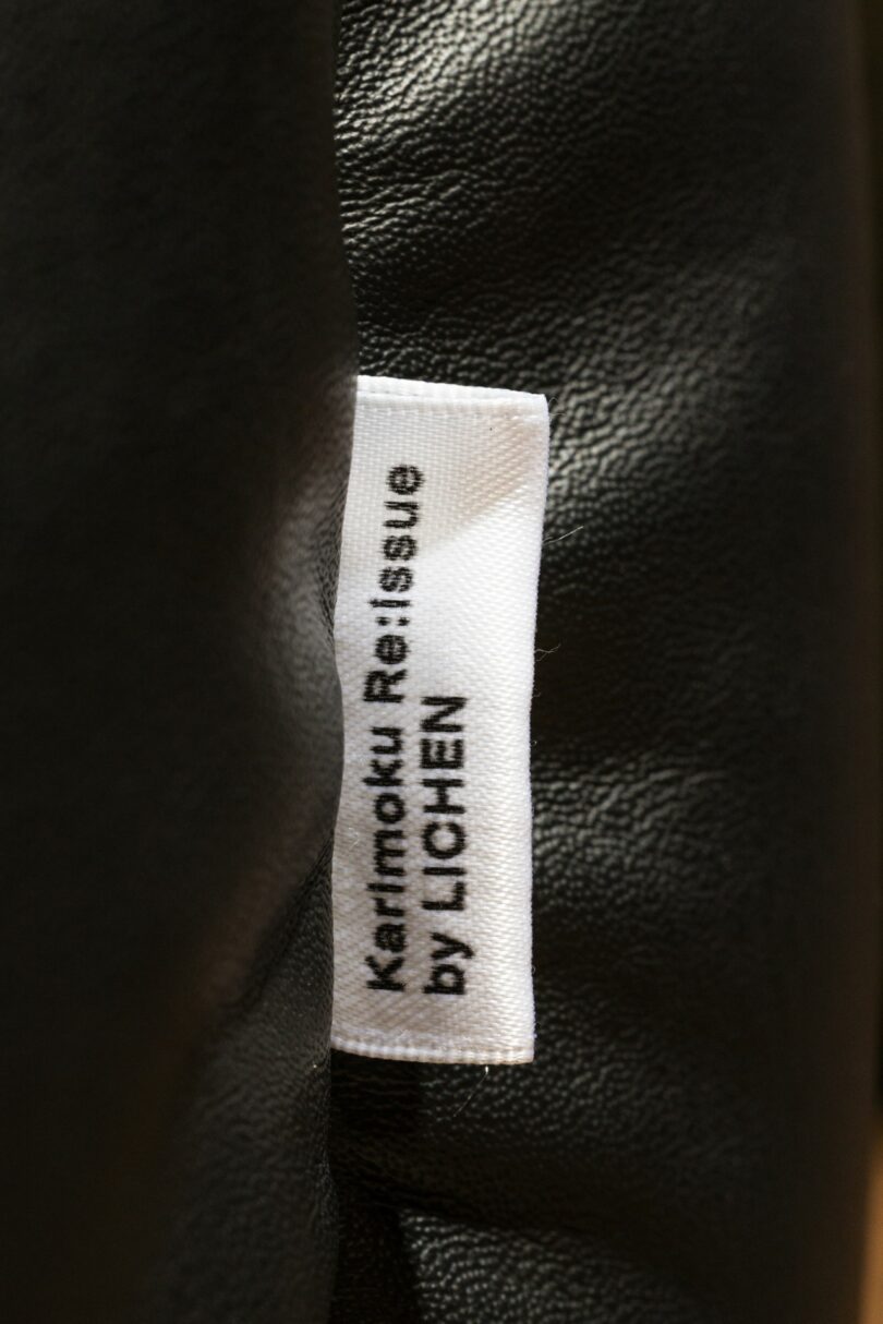 A white fabric label on black material reads "Karimoku Re:Issue by LICHEN" in black text