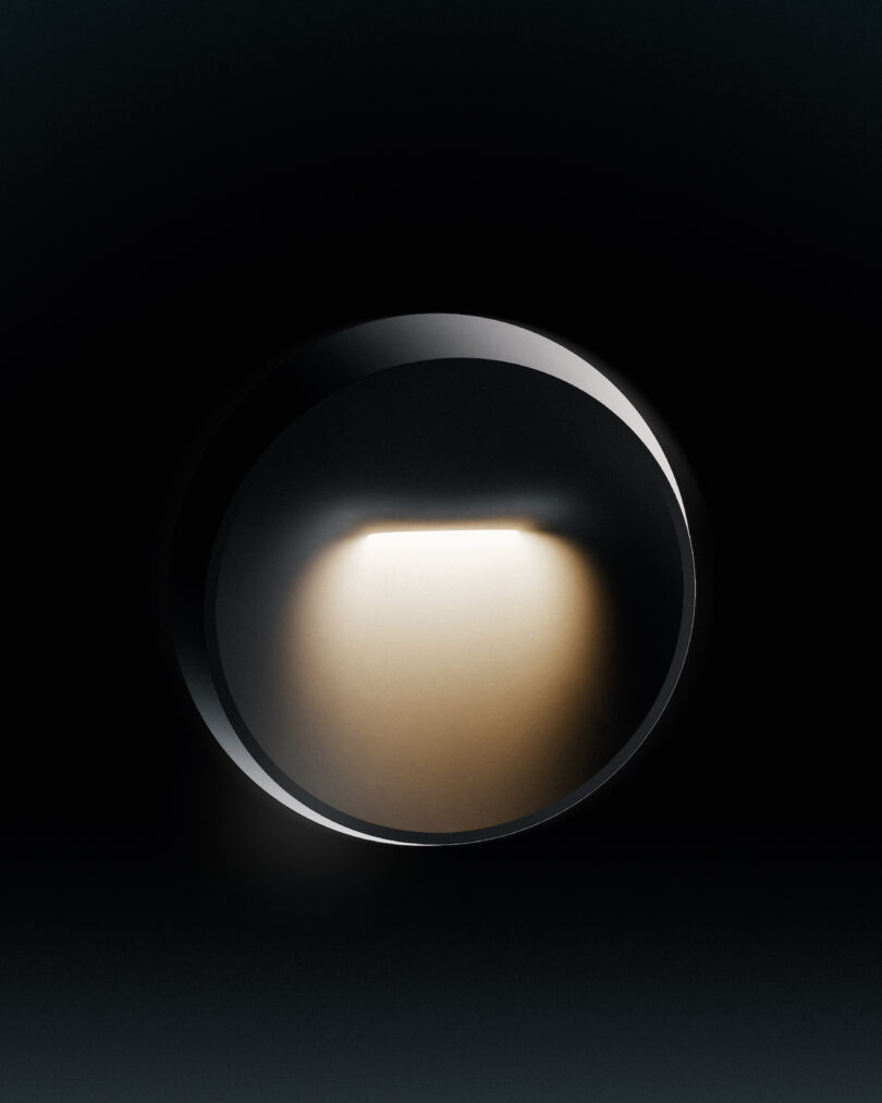 a circular wall light emits a soft, warm glow against a dark background