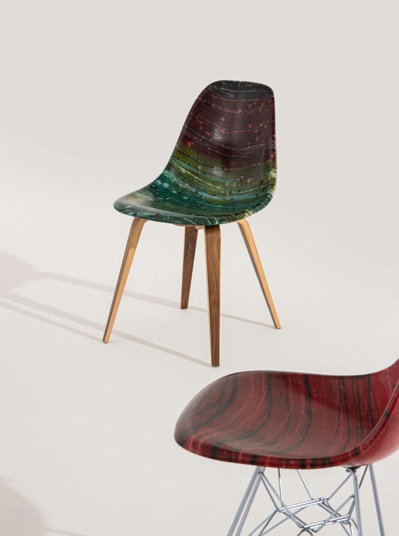 Two modern chairs with colorful, wood-grain patterned seats; one has wooden legs, and the other has a metal wire base, both on a light background.