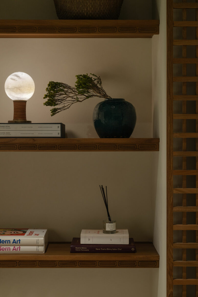 A shelf with books and a vase on it.