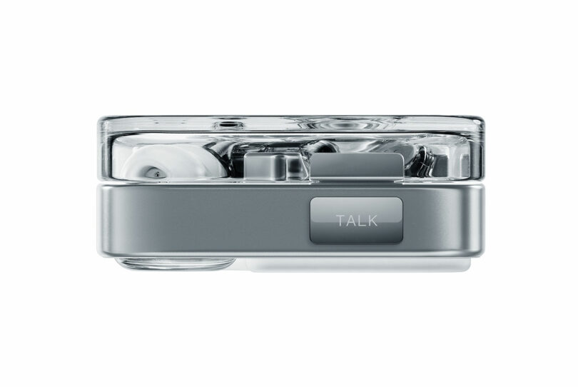 Electrónica rectangular transparente con tapones para los oídos visibles y un botón marcado en el interior "Discurso" En el costado, se muestra sobre un fondo blanco.