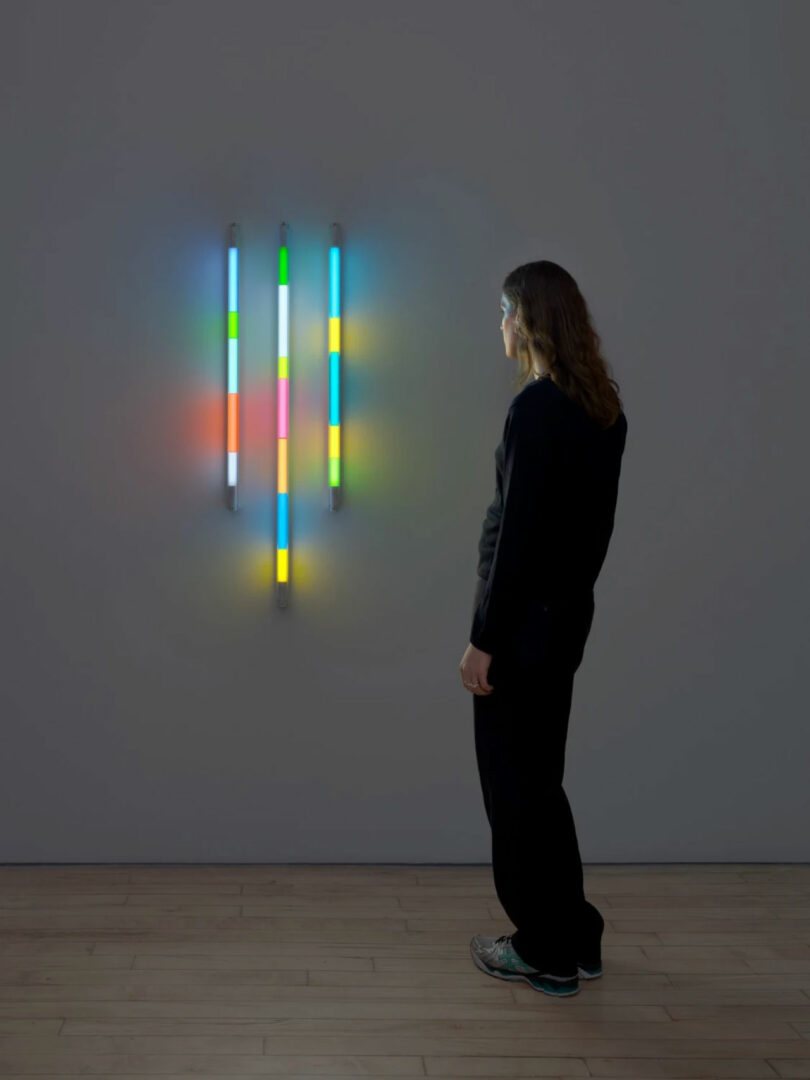 person admiring light sculpture in darkened room