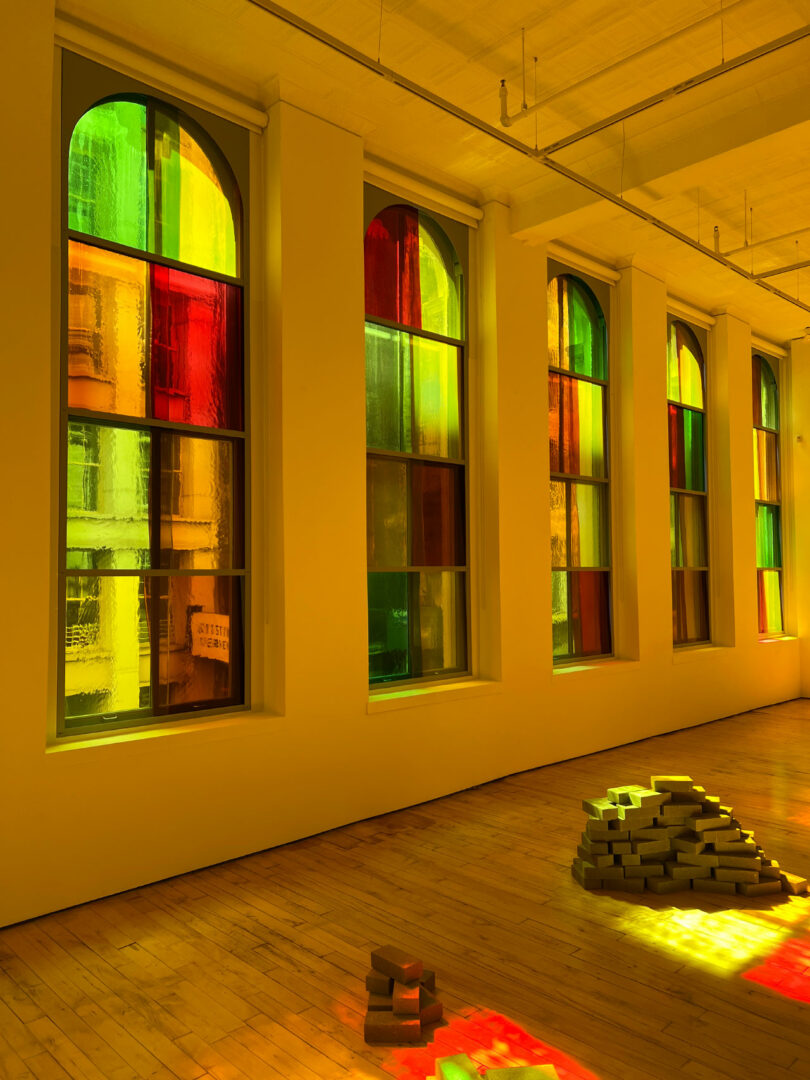 Colored light from stained glass falls on brick piles