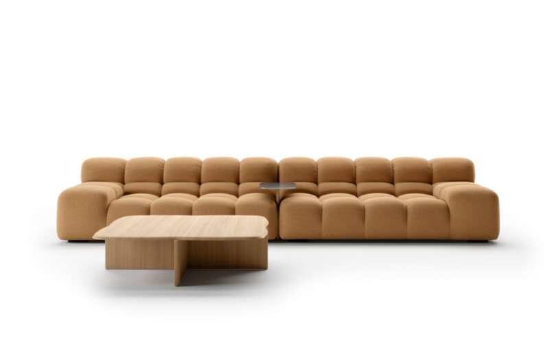 A modern tan sectional sofa with tufted cushions and a small attached side table, paired with a light wood coffee table, set against a white background