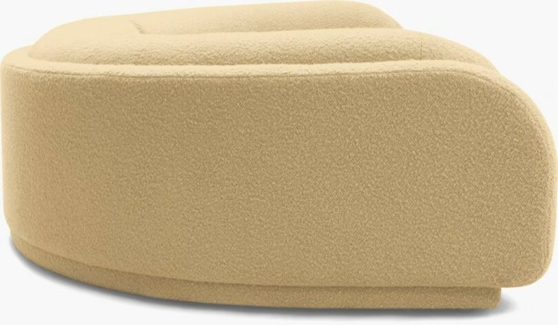 A large, curved beige sectional sofa with a textured fabric and rounded edges, shown against a plain background.