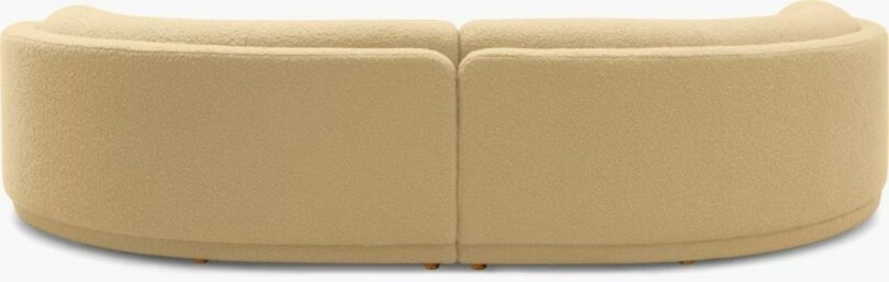A large, curved beige sectional sofa with a textured fabric and rounded edges, shown against a plain background.