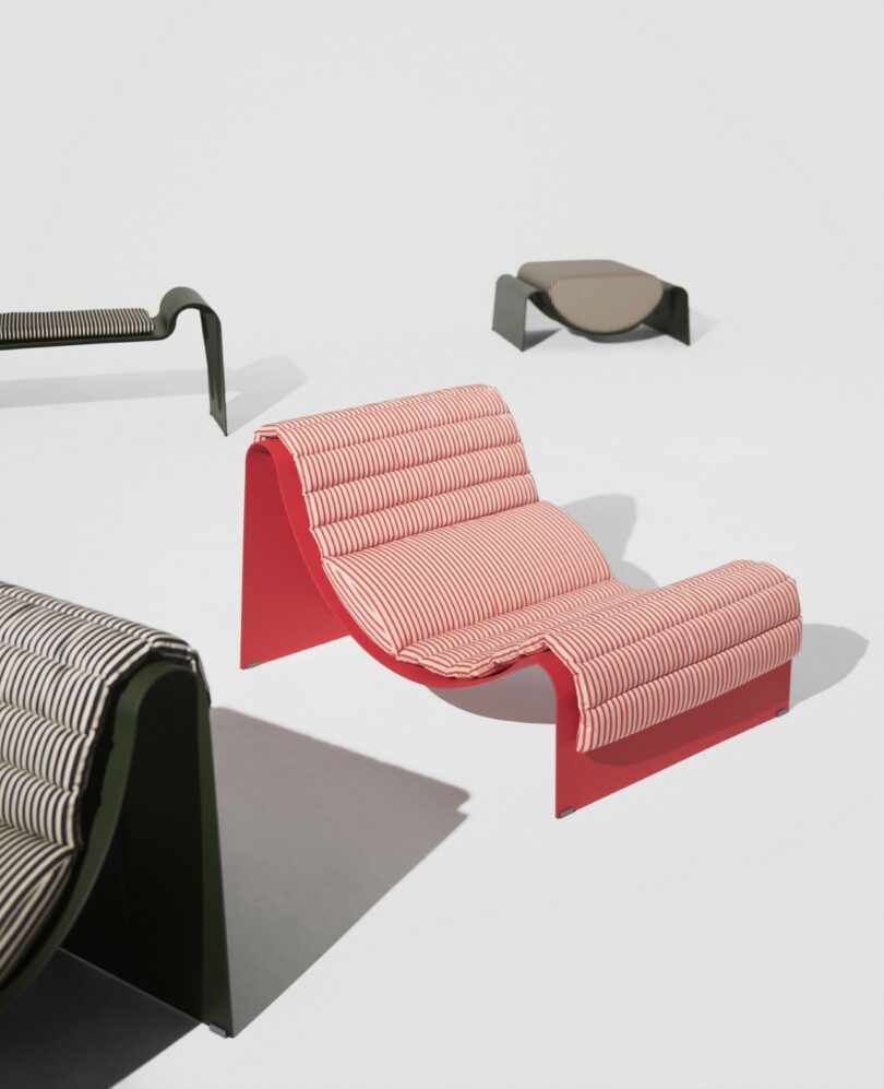 Four modern lounge chairs with wavy designs and patterned fabric upholstery are arranged on a plain white background