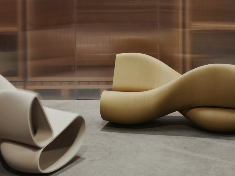 Two sculptural, modern lounge chairs with smooth, curved shapes