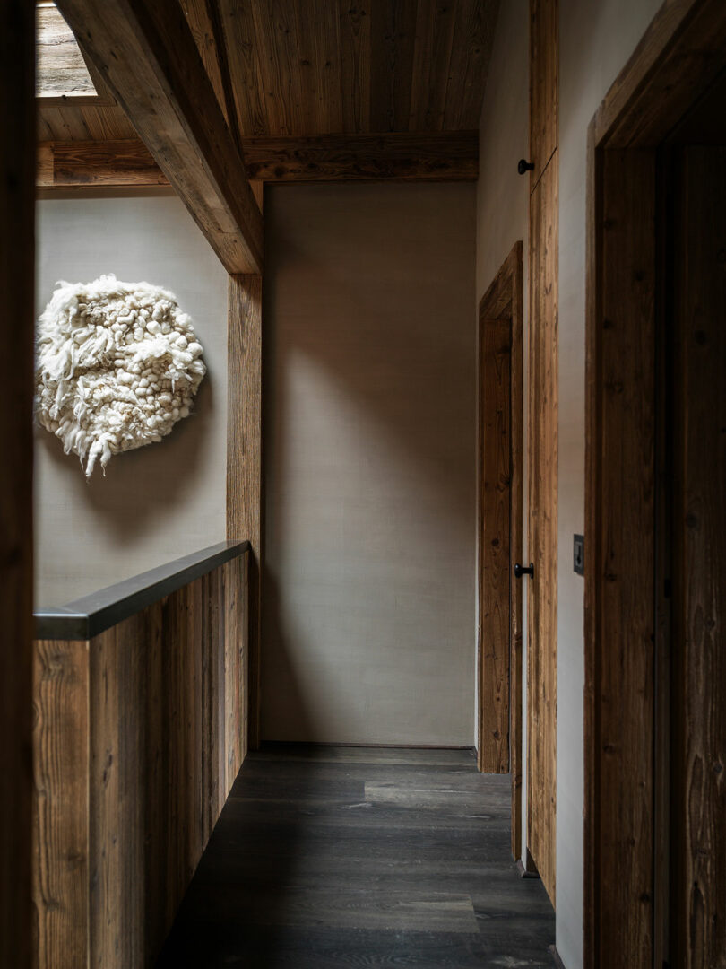 Hallway with wooden walls and ceiling, dark wooden floor and white textured wall shown on the left wall.