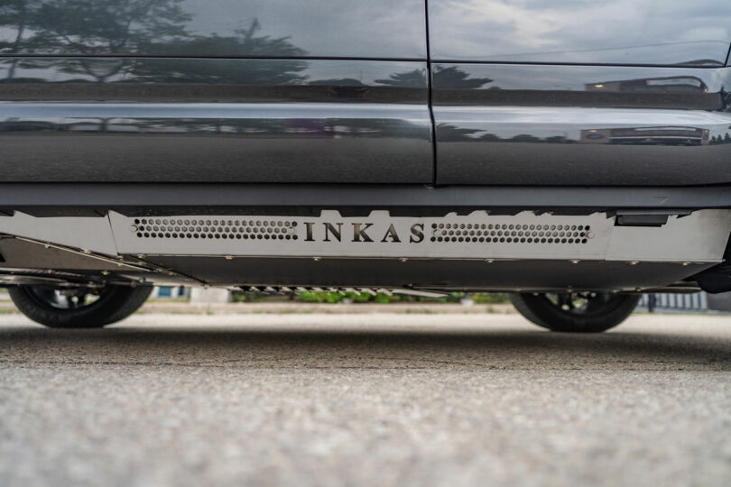Close-up side view of a vehicle with an armored plate labeled "INKAS" installed beneath the doors.