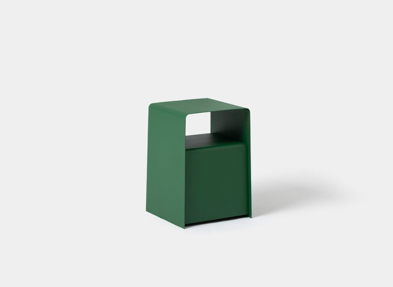 A small, green, rectangular SCP stool with a flat top and open space beneath, set against a plain white background.