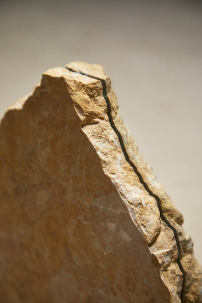 Close-up of the jagged edge of a piece of brownish rock with a visible crack running along its surface