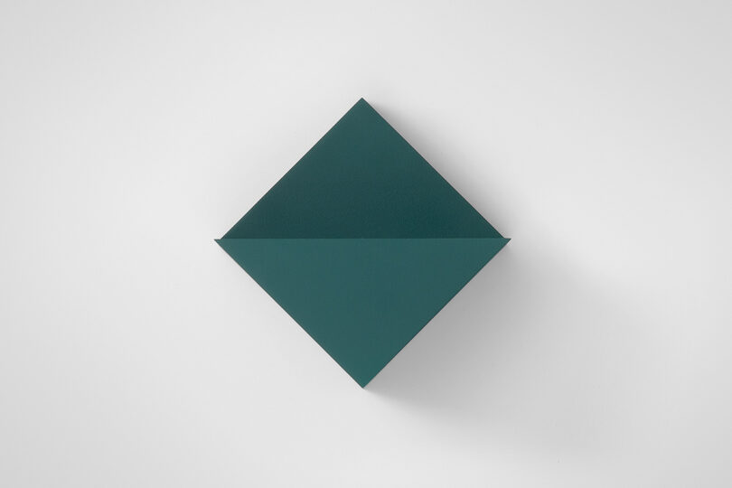 A dark green square envelope is positioned diagonally on a plain white background, resembling a diamond shape.
