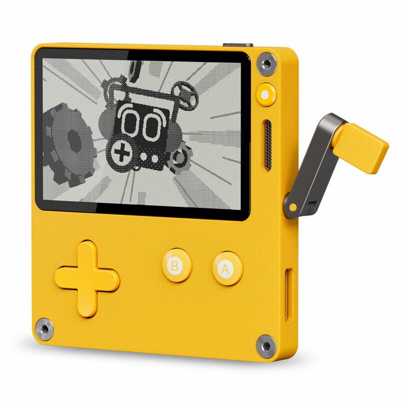 A yellow handheld gaming device with a black-and-white screen, a crank on the side, and yellow control buttons labeled A, B, and a directional pad.