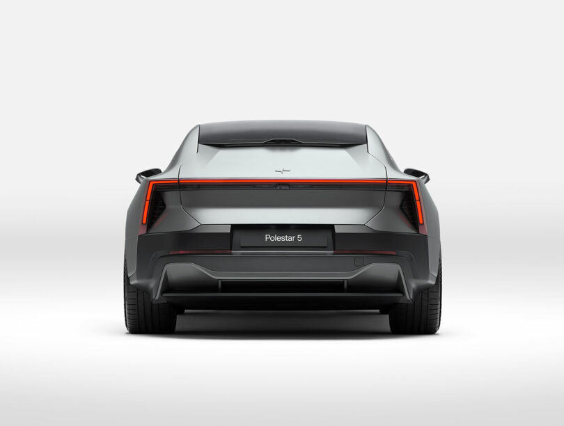 Vista trasera del automóvil eléctrico plateado Polestar 5, que muestra su exclusivo diseño de luces traseras y su carrocería aerodinámica sobre un fondo blanco puro.