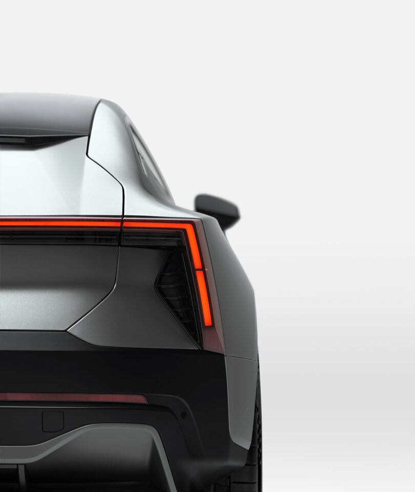 Vista trasera de un automóvil plateado moderno que muestra un diseño de luces traseras en ángulo y líneas nítidas con un fondo gris claro mínimo.