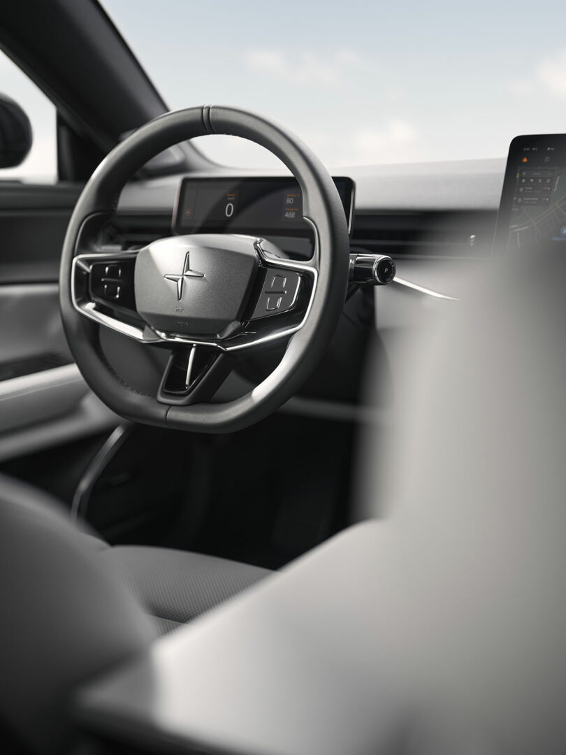 Vista de cerca del volante y el tablero del automóvil Polestar con pantalla digital y diseño interior minimalista.