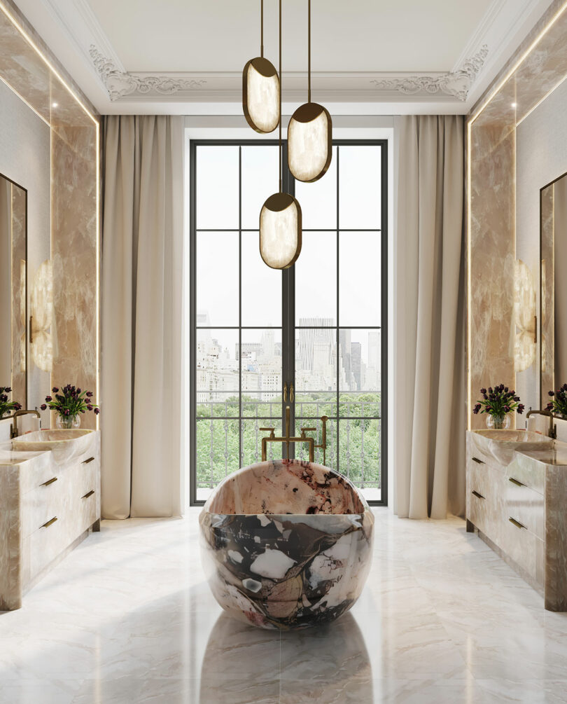 Luxurious bathroom with a large marble bathtub centered under modern pendant lights, flanked by two vanities, and a large window overlooking greenery.