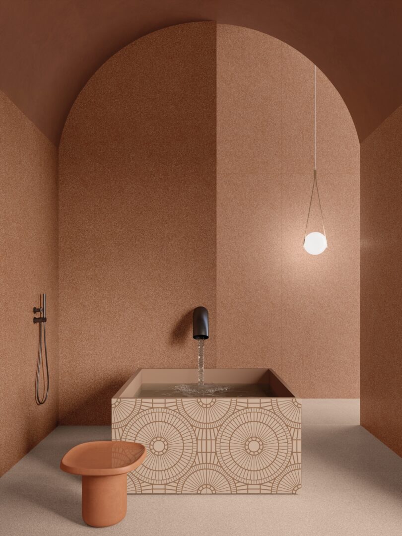 El baño minimalista cuenta con una bañera con azulejos geométricos, accesorios de color negro mate, un taburete redondo de terracota y luces tipo globo suspendidas desde un alto techo abovedado.