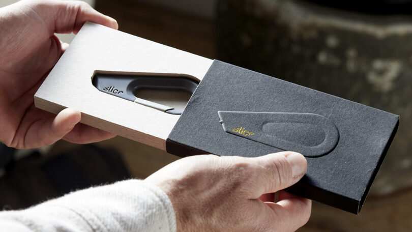 Un hombre abrió una caja blanca y negra que contenía un cuchillo multiusos de la marca Slice.