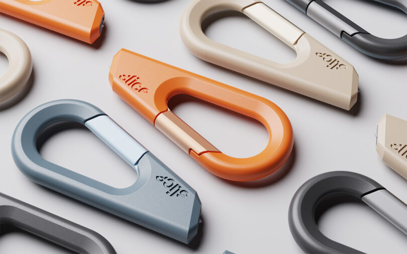 Varios mosquetones modernos y coloridos en naranja, beige, gris y azul dispuestos sobre una superficie blanca.