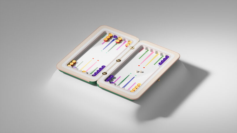 Juego de backgammon cuidadosamente arreglado con coloridas piezas de ajedrez y dados exhibidos en una caja rectangular abierta sobre una superficie gris