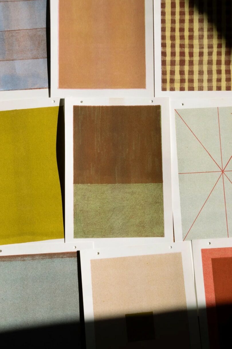 Nueve impresiones de arte abstracto con varias formas geométricas, colores y patrones dispuestos en una cuadrícula, parcialmente cubiertos por sombras a la derecha