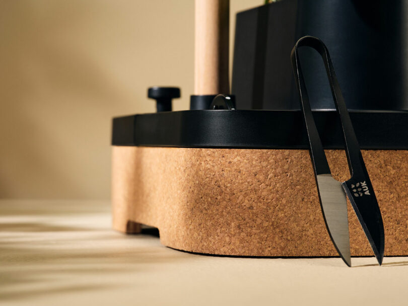 Al lado del tablero de corcho hay unas tijeras.