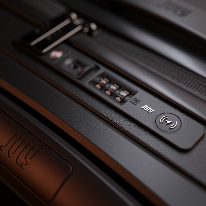 Cierre del mecanismo de bloqueo de la maleta con cerradura de combinación numérica y nombre de marca "Julio" Visible en superficies negras.