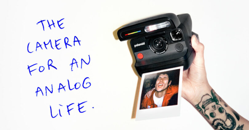 Una mano tatuada sostiene una cámara Polaroid e imprime una fotografía de una persona sonriente; texto escrito a mano lee, "Una cámara que simula la vida.