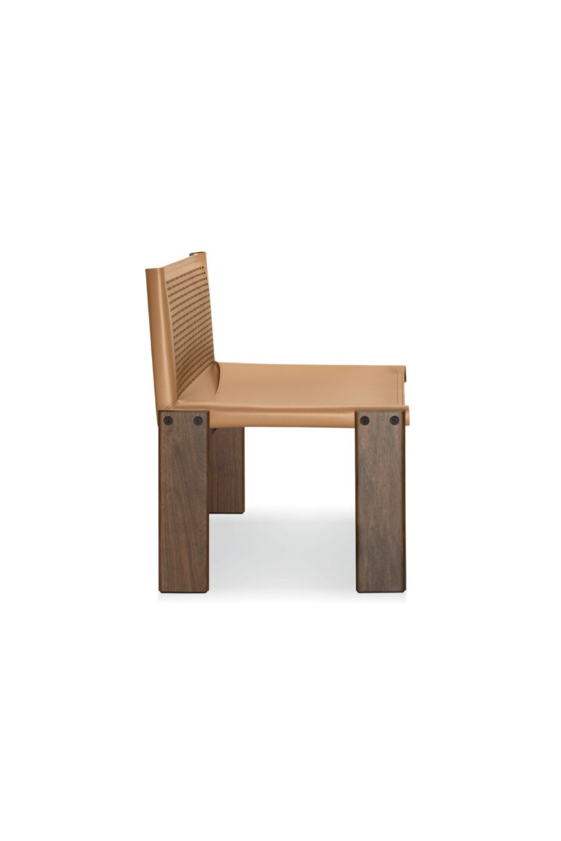 Una silla moderna con asiento de cuero color canela, respaldo de cuero perforado y estructura de madera, rodada contra un fondo blanco