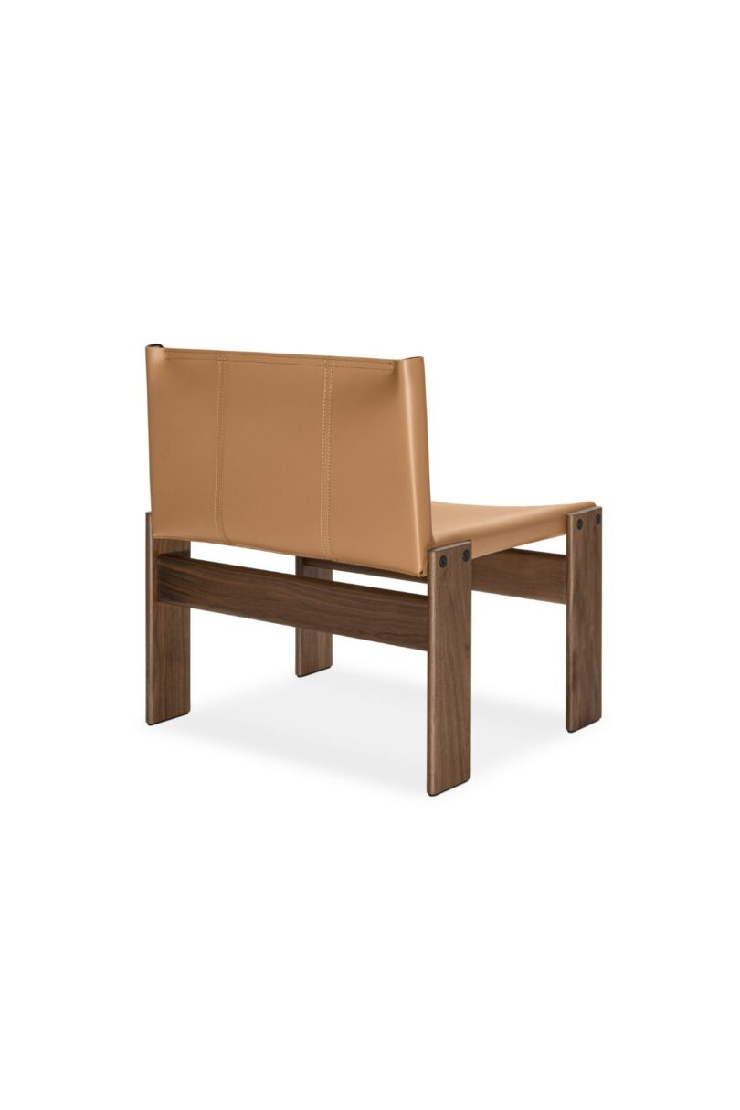 Un sillón moderno con asiento y respaldo de cuero color canela sostenido por un marco de madera oscura, mostrado desde la esquina trasera sobre un fondo blanco