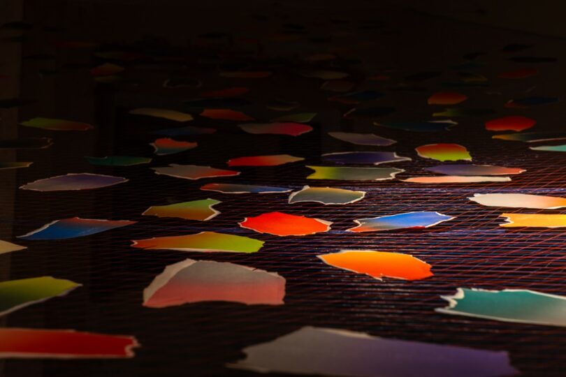 Formas de papel coloridas cuelgan de cuerdas en el interior. 