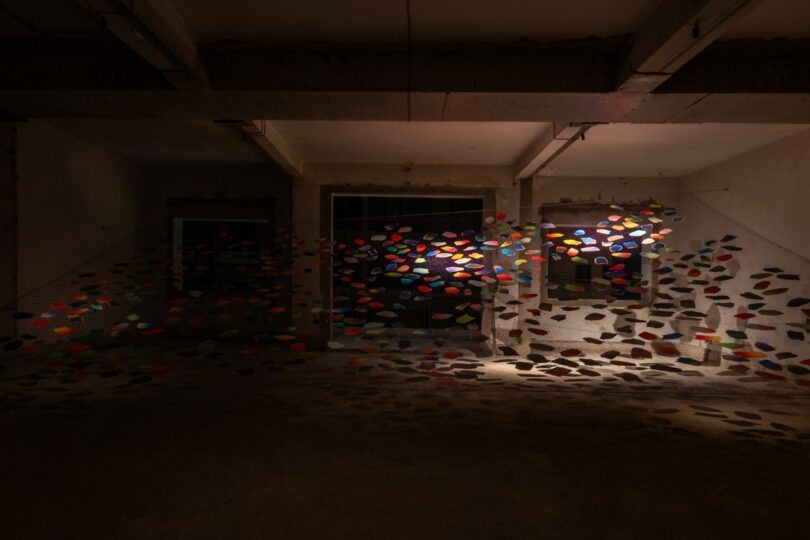 Formas de papel coloridas cuelgan de cuerdas en el interior. 