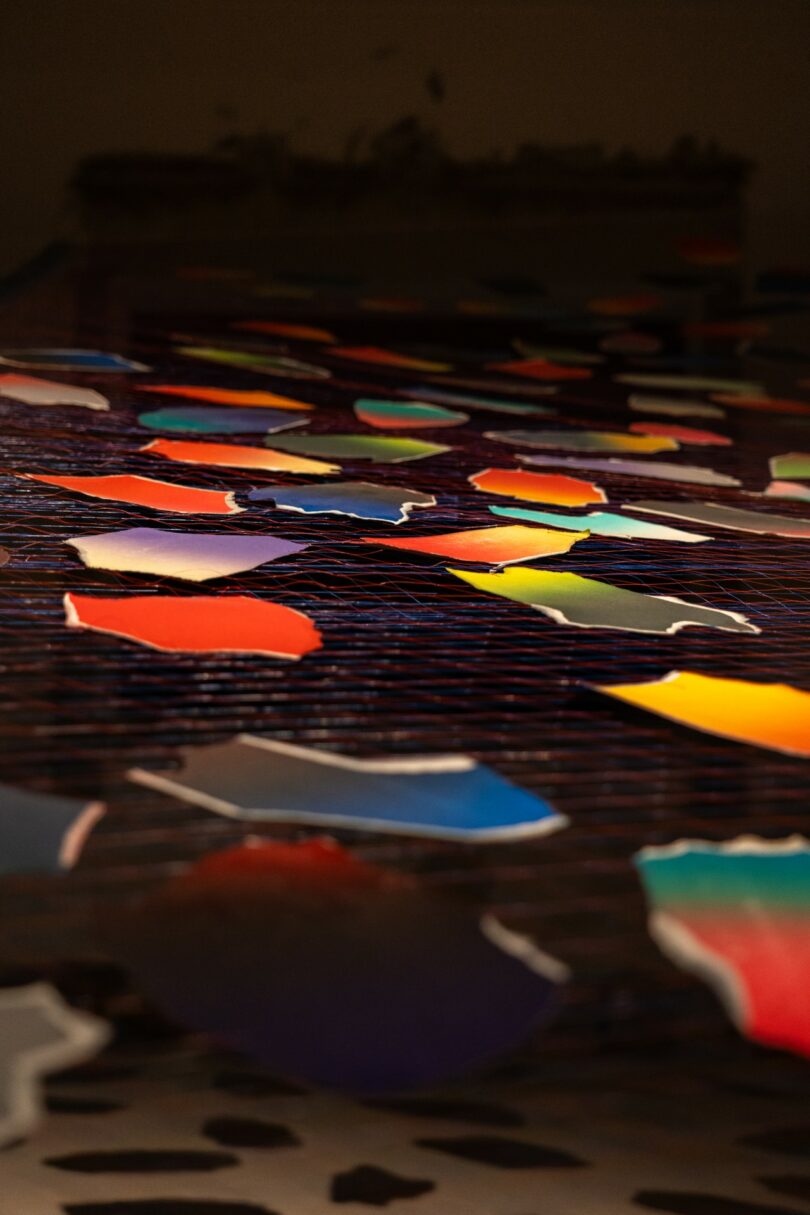 Formas de papel coloridas cuelgan de cuerdas en el interior. 