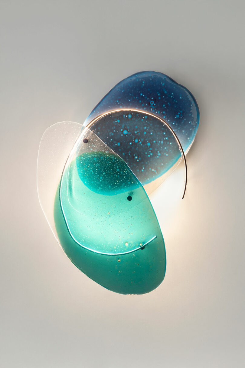 Transparencias de vidrio azul sobre pared blanca.