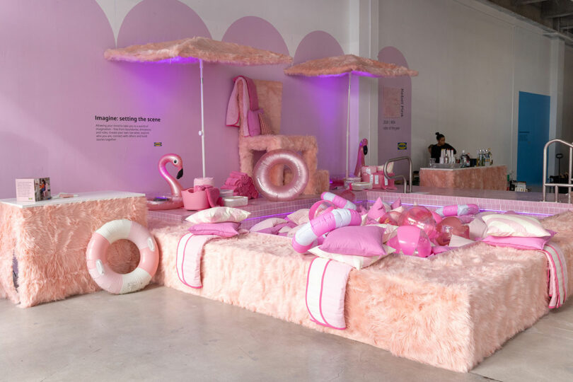 A screening area features pink faux fur furniture, inflatable pool floats, pillows and towels under purple lighting, with a person standing at a bar in the background.