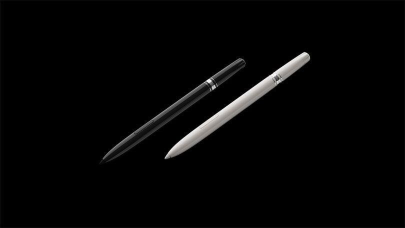 A black pen and a white pen, designed by Fuseproject, are positioned diagonally side by side on a solid black background.