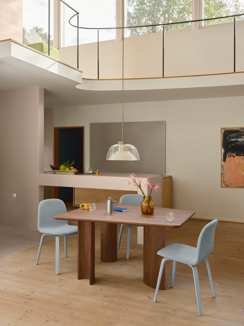 En la sala de techos altos hay una mesa de comedor y sillas.