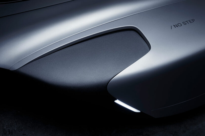 Cerca del guardabarros plateado brillante con pequeñas luces y texto "sin pasos" impreso en la superficie.