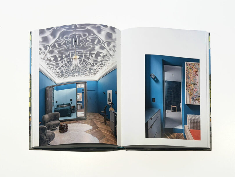 An open book displays interior photos of a modern blue room with a sculpted white ceiling, contemporary furniture, and wall art—perfect for anyone needing to Take 5 and find design inspiration.