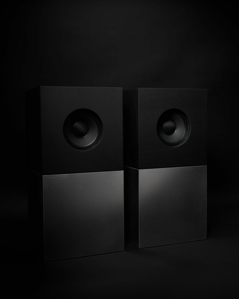 Two black rectangular speakers from Studio D.A and Nocs debut the Braque stereo system, positioned side by side against a dark background.